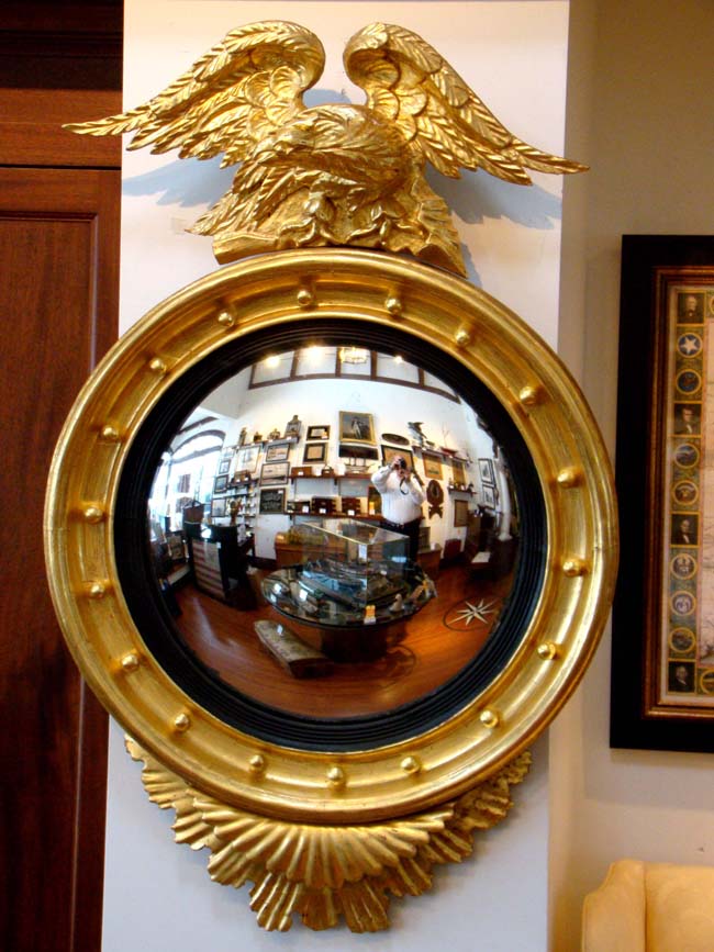 A Federal period Convex Mirror in a carved gilt wood frame surmounted by an eagle circa 1810-1820